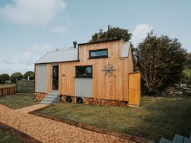 A tiny house with wooden exterior and steps at Rowan in Carreglefn near Llanfechell