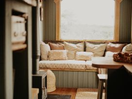 A snug with a sofa and cushions at Rowan in Carreglefn near Llanfechell