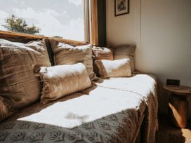 A sofa with cushions and a table at Rowan in Carreglefn near Llanfechell