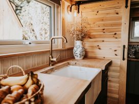 A kitchen with a sink and wooden counter at Rowan in Carreglefn near Llanfechell
