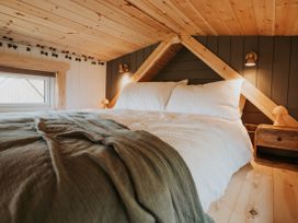 A bedroom with a bed and nightstand at Rowan in Carreglefn near Llanfechell