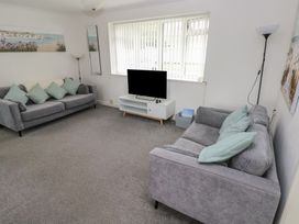 A living room with a sofa and TV at Chalet 26 in Scurlage