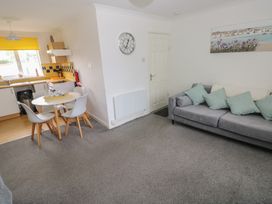 A living room with a dining area and kitchen in Chalet 26 Scurlage