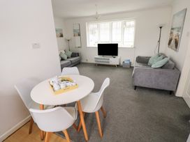 A living room with a sofa and television at Chalet 26 in Scurlage