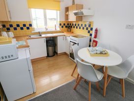 A kitchen with a table and chairs at Chalet 26 in Scurlage