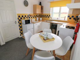 A kitchen with a dining table and appliances at Chalet 26 in Scurlage