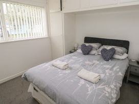 A bedroom with a bed and pillows at Chalet 26 in Scurlage