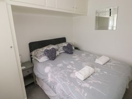 A bedroom with a bed and nightstand at Chalet 26 in Scurlage