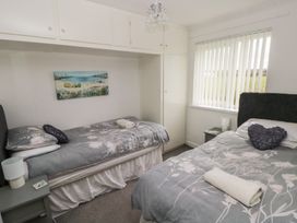 A bedroom with two beds and a nightstand at Chalet 26 in Scurlage