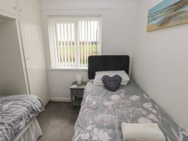 A bedroom with a bed and a window at Chalet 26 in Scurlage