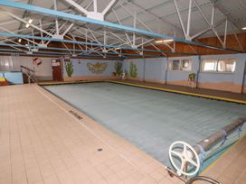 An indoor pool with a cover and ladder at Chalet 26 in Scurlage