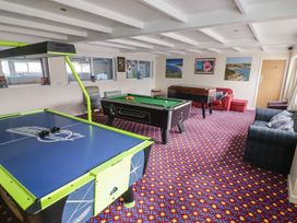 A game room with air hockey, pool and foosball tables at Chalet 26 in Scurlage