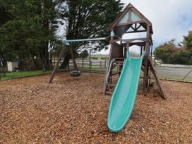 A playground with a slide and swing at Chalet 26 Scurlage