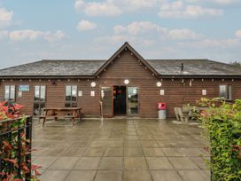 A wooden building with outdoor seating area at Dashing Dennis - 22 in Chapmanswell near Launceston