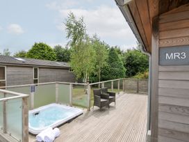 An outdoor area with a hot tub and seating at 3 Meadow Retreat in Liskeard