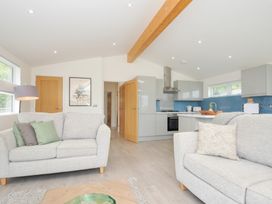 A living room with a sofa and kitchen in 3 Meadow Retreat Liskeard