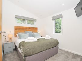 A bedroom with a bed and window at 3 Meadow Retreat in Liskeard