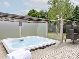A hot tub on a wooden deck with champagne at 3 Meadow Retreat in Liskeard
