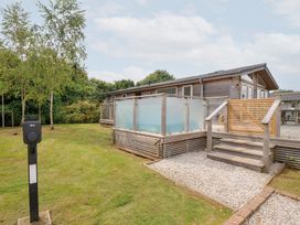 An outdoor area with a wooden house and charging station at 3 Meadow Retreat in Liskeard