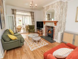 A living room with a sofa, armchair, coffee table, and fireplace at 5 Jackson Terrace, Morpeth