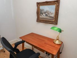 An office with a desk, chair, lamp, and painting at 5 Jackson Terrace in Morpeth