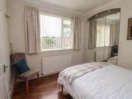 A bedroom with a bed, chair, mirror, and window at 5 Jackson Terrace in Morpeth