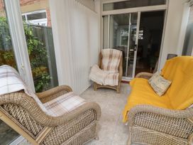 A conservatory with armchairs and a sliding glass door at 5 Jackson Terrace Morpeth