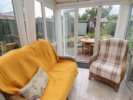 A conservatory with a sofa and armchair at 5 Jackson Terrace in Morpeth