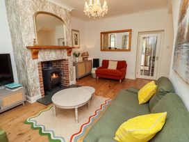 A living room with a fireplace and seating area at Rose Briar Cottage in Morpeth