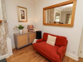 A living room with a sofa and a lamp at Rose Briar Cottage in Morpeth