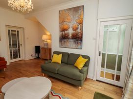 A living room with a green sofa and a coffee table at Rose Briar Cottage in Morpeth