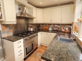 A kitchen with a stove, oven, and sink at Rose Briar Cottage in Morpeth