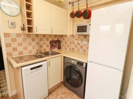 A kitchen with appliances and cabinets at Rose Briar Cottage in Morpeth
