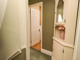 A hallway with a cabinet and a door at Rose Briar Cottage in Morpeth