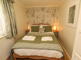 A bedroom with a bed and bedside table at Rose Briar Cottage in Morpeth