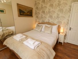 A bedroom with a bed and bedside table at Rose Briar Cottage in Morpeth