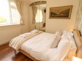 A bedroom with a bed and mirror at Rose Briar Cottage in Morpeth