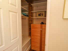 A closet with shelves and a storage cabinet at Rose Briar Cottage in Morpeth