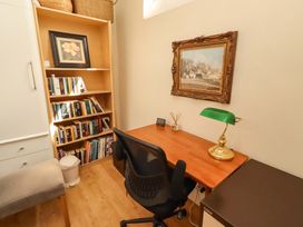 An office with a desk, chair, and bookshelf at Rose Briar Cottage in Morpeth