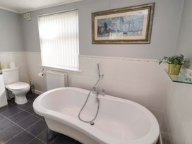 A bathroom with a bathtub and toilet at Rose Briar Cottage Morpeth
