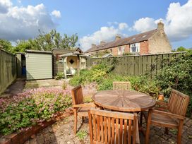 A garden with a table and chairs at Rose Briar Cottage in Morpeth