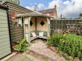 A garden seating area with a wooden structure at Rose Briar Cottage Morpeth