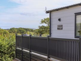 An outdoor view of a house with a sign at Maple Lodge in Teigngrace near Kingsteignton
