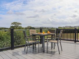 An outdoor dining area with a table and chairs at Maple Lodge in Teigngrace near Kingsteignton