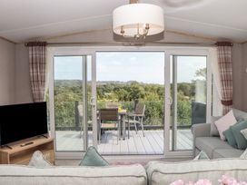 A living room with a sofa and television at Maple Lodge in Teigngrace near Kingsteignton