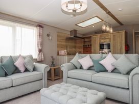 A living room with sofas and kitchen unit at Maple Lodge Teigngrace near Kingsteignton