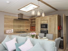 A kitchen with dining area and appliances at Maple Lodge Teigngrace near Kingsteignton