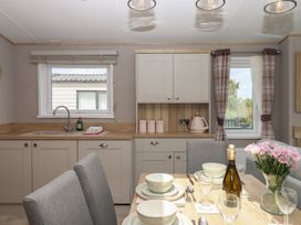 A kitchen with a dining table set at Maple Lodge in Teigngrace near Kingsteignton