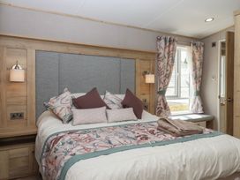 A bedroom with a bed and window at Maple Lodge Teigngrace near Kingsteignton