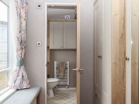 A bathroom with a toilet and towel rack at Maple Lodge Teigngrace near Kingsteignton